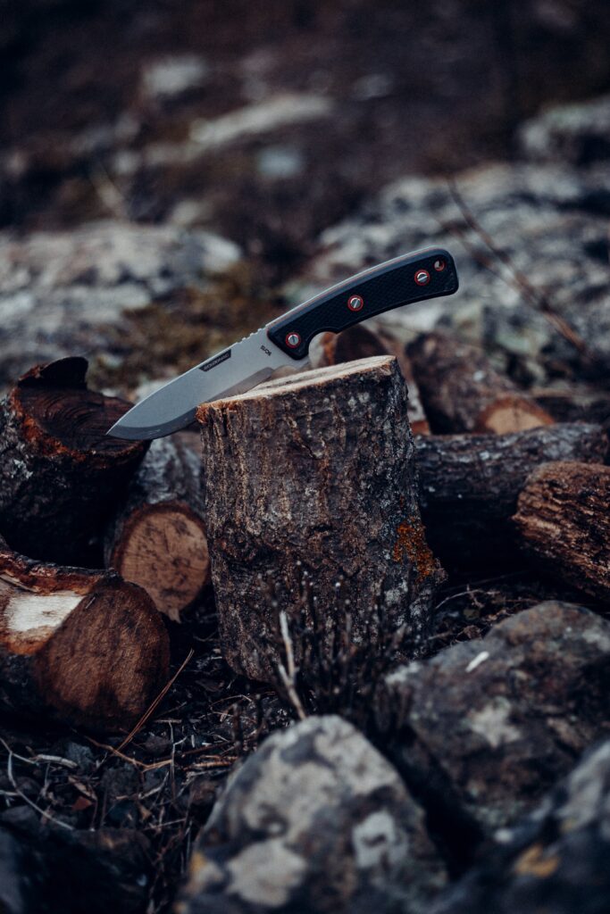 A hunting knife in a wood log